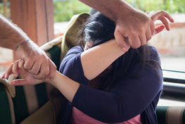 A woman being held recklessly in both hands